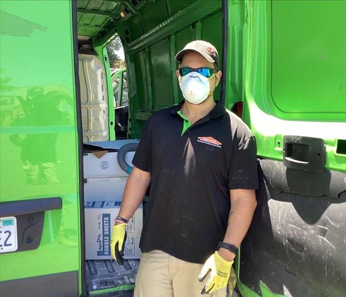 technician standing next to servpro van in mask and gloves