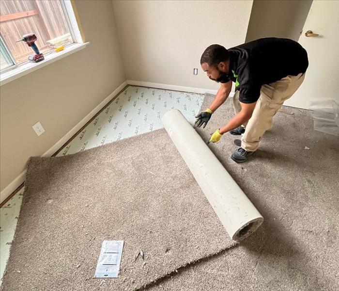 man removing damaged carpet