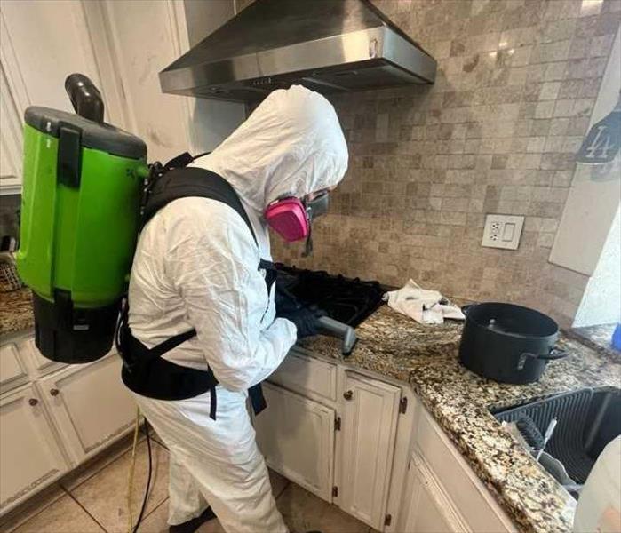 man in PPE cleaning a counter top