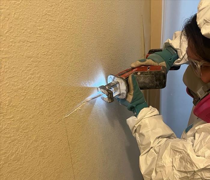 technician making a precise cut on a wall